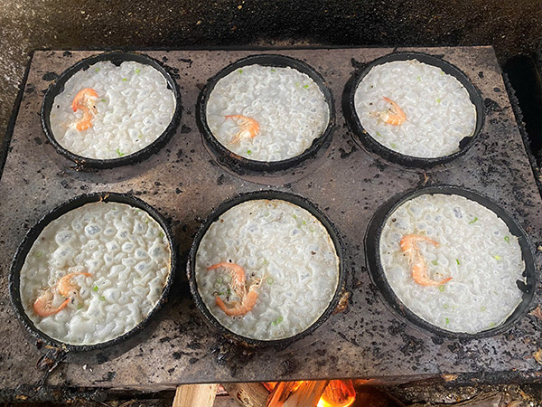 Cooking Banh Xeo Quang Ngai in a small pan